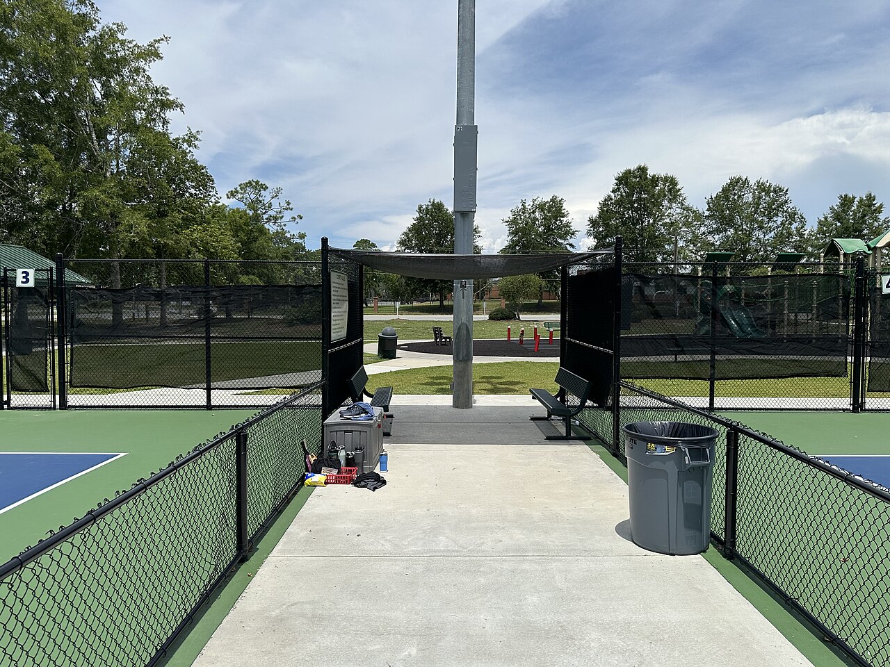 Located in between pickleball courts 3 and 4 at Harry B. Anderson Tennis Center in Valdosta, Georgia, United States. The entrance features 2 benches p
