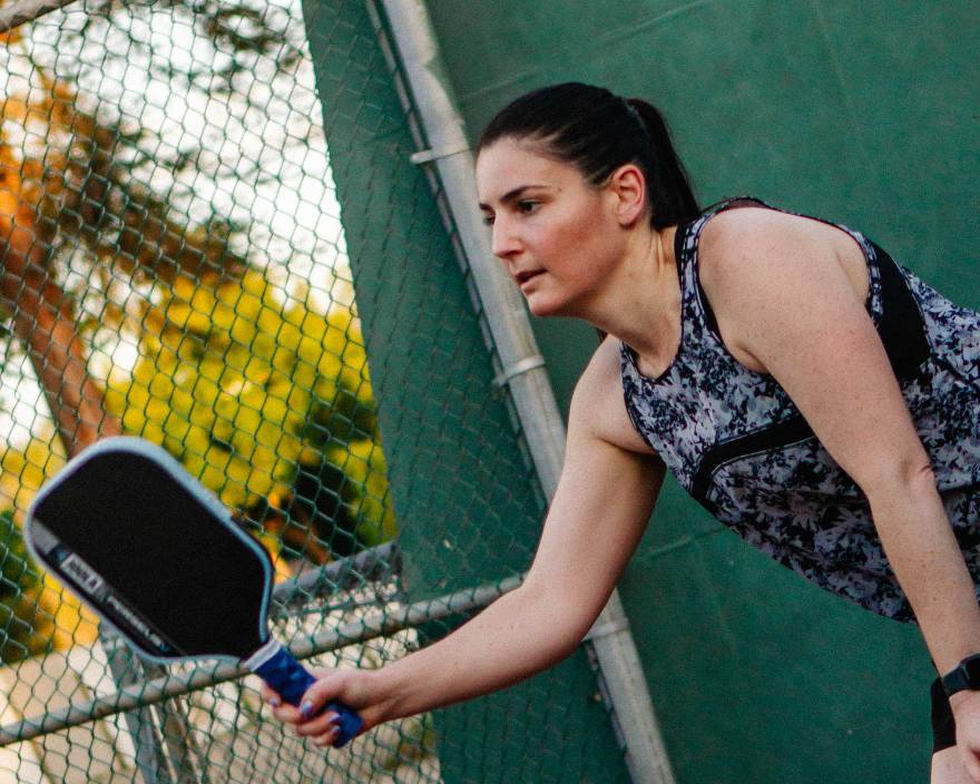 Player reaching for a low ball during an outdoor Los Angeles pickleball session